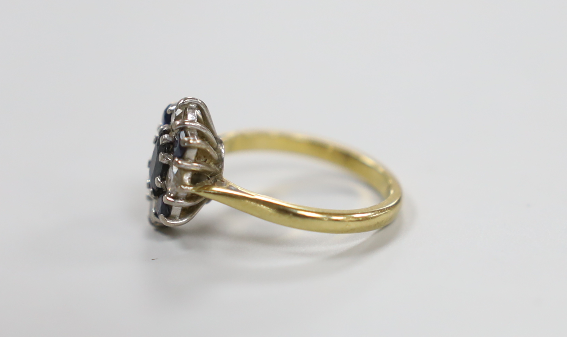 A modern 18ct gold, sapphire and diamond cluster set ring, size M, gross weight 4.4 grams.